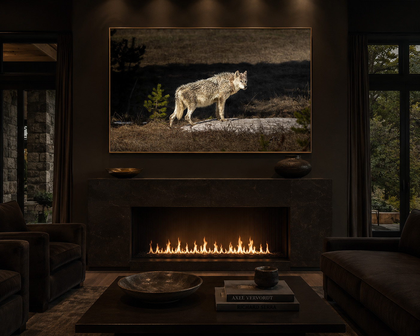 Wide horizontal framed print of 1577F, a white wolf lit by low golden light, hung above a dark stone fireplace in a moody, warm-lit study.